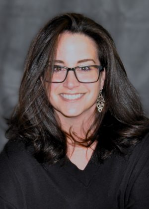Photo of Dr. Consolino, wearing glasses and a black sweater.